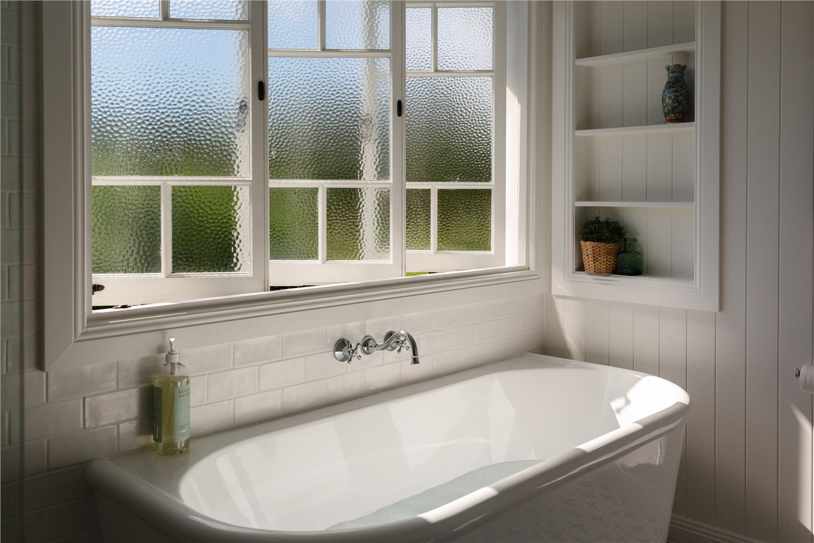 Bathroom with bath and textured glass windows